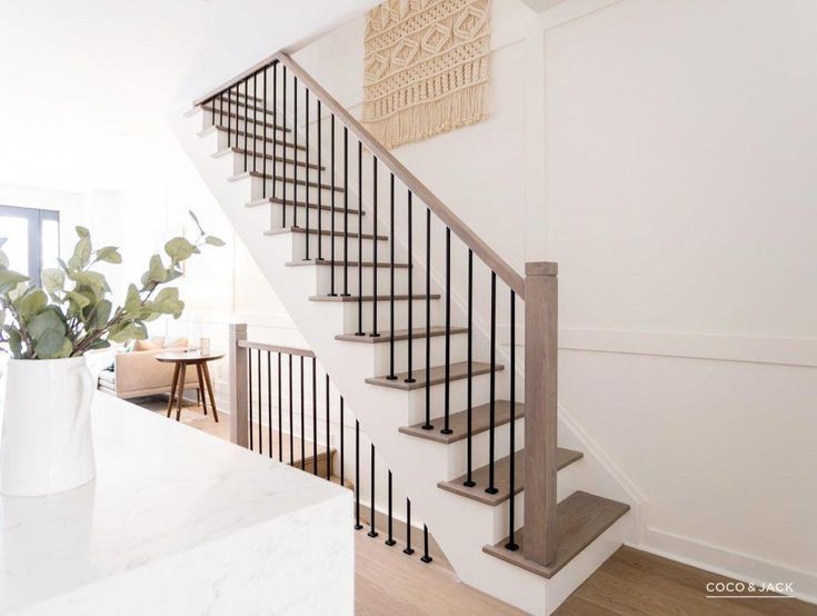 Modern staircase with stained and painted poplar wood parts and iron balusters